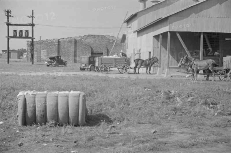 At the cotton gin. Cotton gin and wagons. Hale County, Alabama.