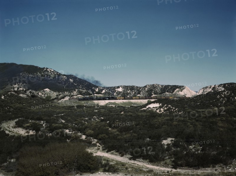 Freight train with two helper engines climbing the steep grade of Cajon Pass (westbound), CA., 1943. Creator: Jack Delano.