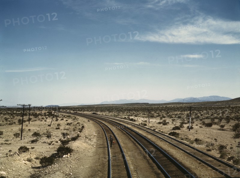 Flagman standing at a distance behind a Santa Fe R.R. west bound freight..., Bagdad, Calif., 1943. Creator: Jack Delano.