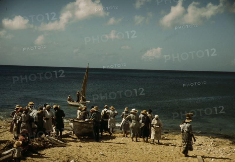 Housewives at the seashore waiting for the fishing boats to come in Frederiksted, V.I., 1941. Creator: Jack Delano.