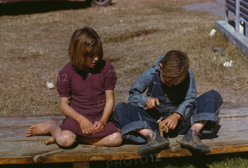 Boy building a model airplane as girl watches, FSA ... camp, Robstown, Tex., 1942. Creator: Arthur Rothstein.