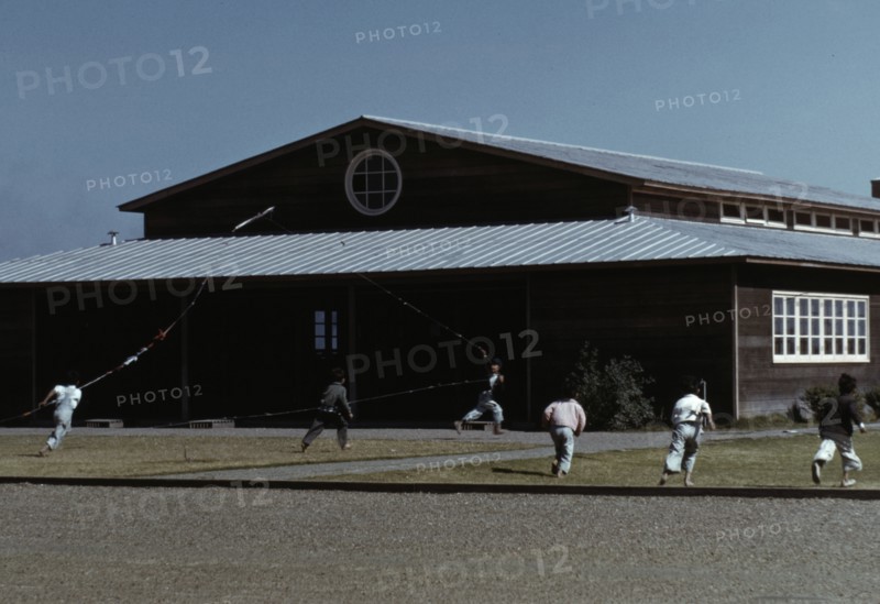 Boys flying a kite in front of community center, FSA ... camp, Robstown, Tex., 1942. Creator: Arthur Rothstein.