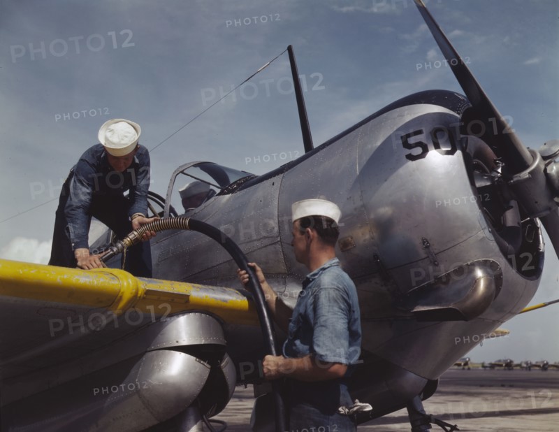 Feeding an SNC advanced training plane its essential supply of gas...Corpus Christi, Texas, 1942. Creator: Howard Hollem.