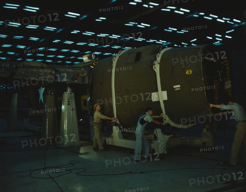 Putting the nose section of a mighty transport...Consolidated Aircraft..., Fort Worth, Texas, 1942. Creator: Howard Hollem.