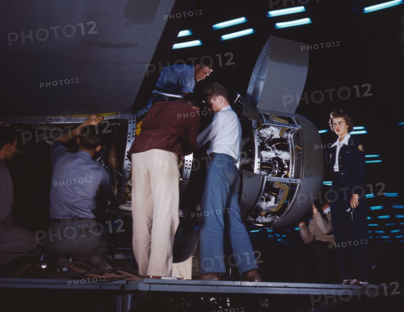 Installing an engine at the Consolidated Aircraft Corporation plant, Fort Worth, Texas, 1942. Creator: Howard Hollem.