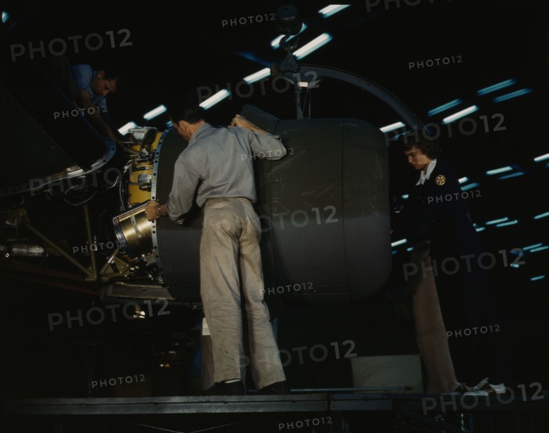 Lowering an engine in place in assembling a C-87...Consolidated Aircraft..., Fort Worth, Texas, 1942 Creator: Howard Hollem.