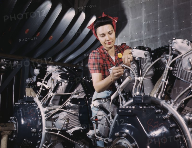Woman working on an airplane motor at North American Aviation, Inc., plant in Calif., 1942. Creator: Alfred T Palmer.