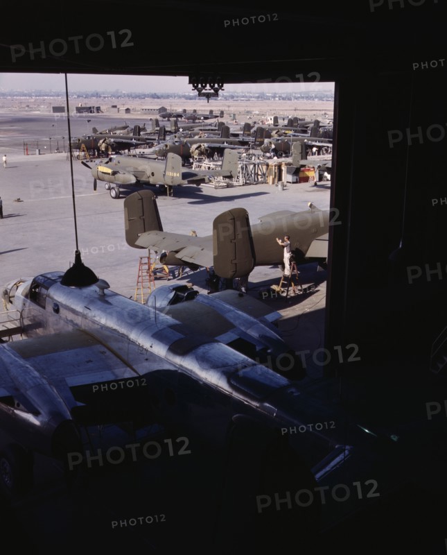 Another North American B-25 bomber rolls off the final assembly line to join other ships..., 1942. Creator: Alfred T Palmer.