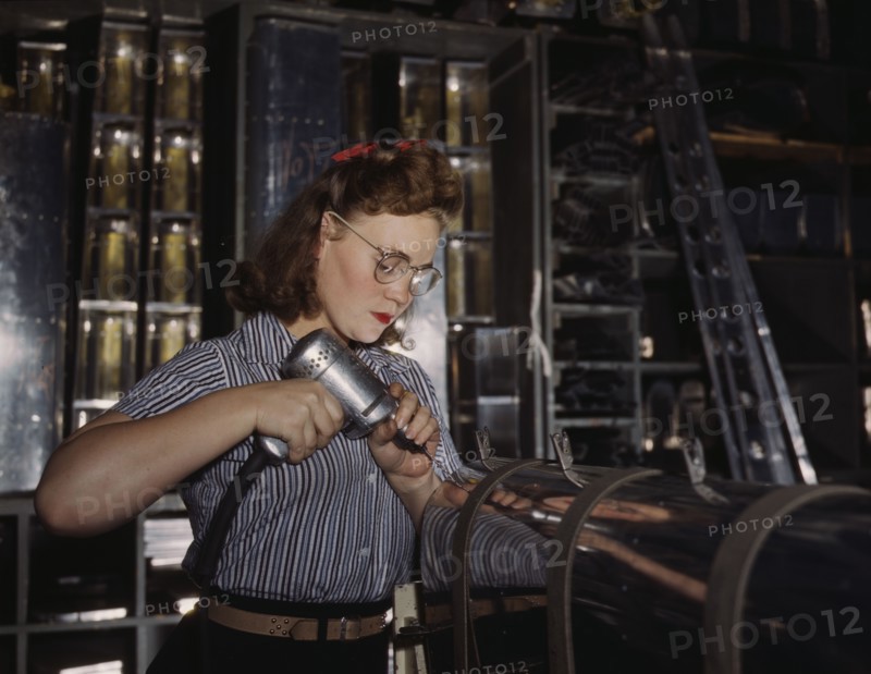 Operating a hand drill at the North American Aviation, Inc., a woman is in the control..., 1942. Creator: Alfred T Palmer.