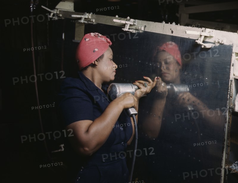 Operating a hand drill at Vultee-Nashville...working on a "Vengeance" dive bomber, Tennessee, 1943. Creator: Alfred T Palmer.