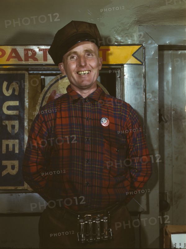 Garage mechanic near Newark, N.J. Badge denotes member of Office of Defense Transportation, 1943. Creator: Marjory Collins.