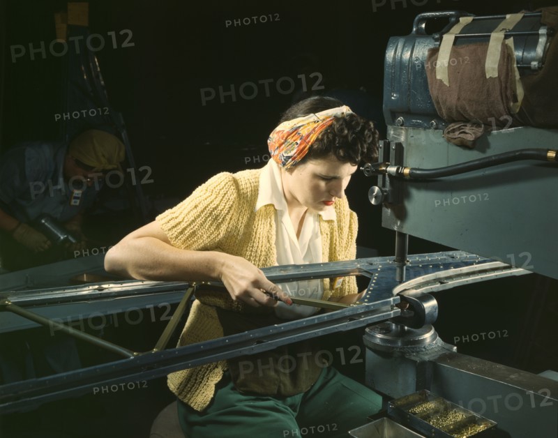 A girl riveting machine operator at the Douglas Aircraft Company plant..., Long Beach, Calif. , 1942 Creator: Alfred T Palmer.