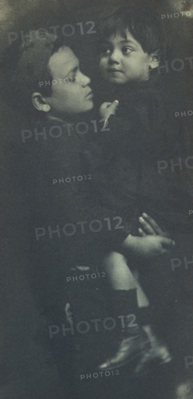Young boy holding a smaller child, c1900.
