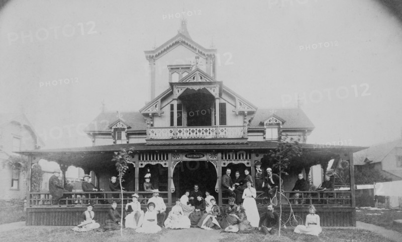 Frances Benjamin Johnston and family on porch and in front of house, between 1890 and 1910.