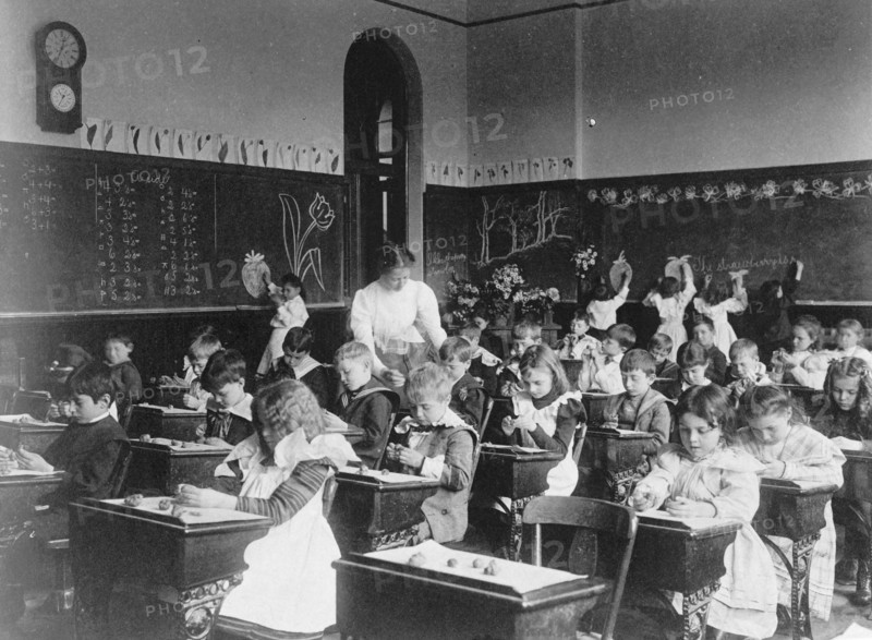 Children modeling clay at desks and drawing on blackboard in Washington, D.C. classroom, (1899?).