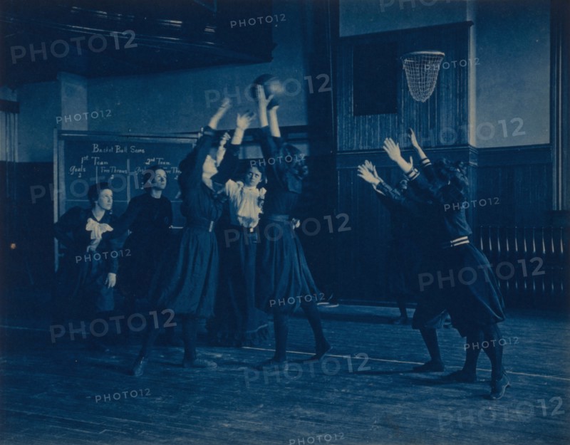 Female students playing basketball in a gymnasium, Western High School, Washington, D.C., (1899?).