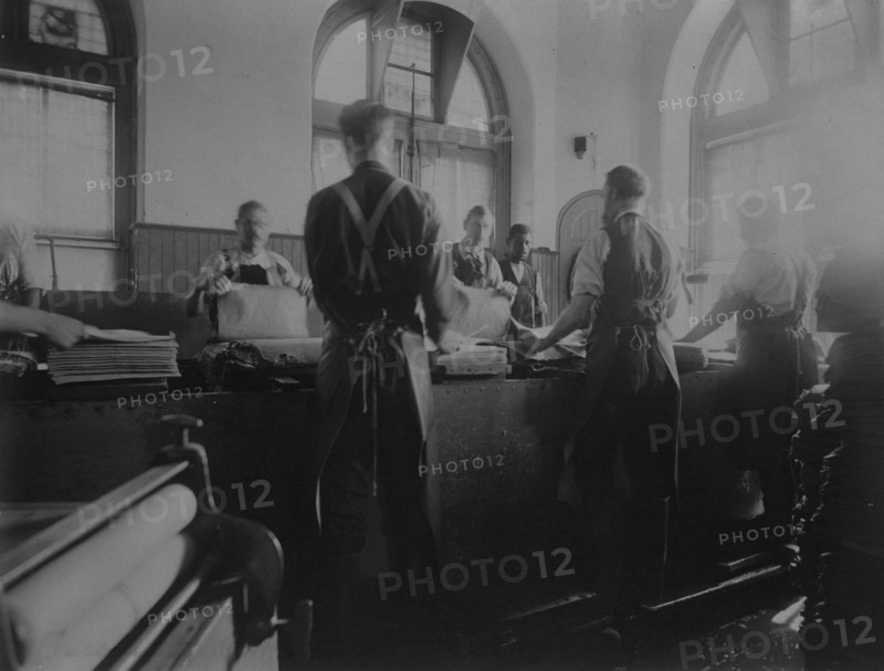 Workers wetting sheets prior to printing paper money at the Bureau of Engraving & Printing, c1895.