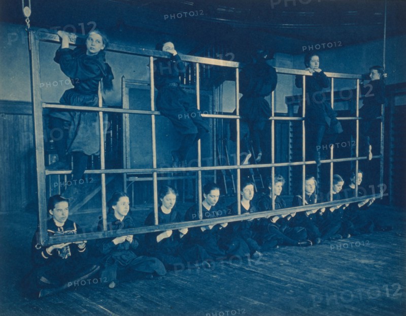 Female students posing with exercise equipment in a gymnasium, Western High School, Washington, D.C., (1899?).