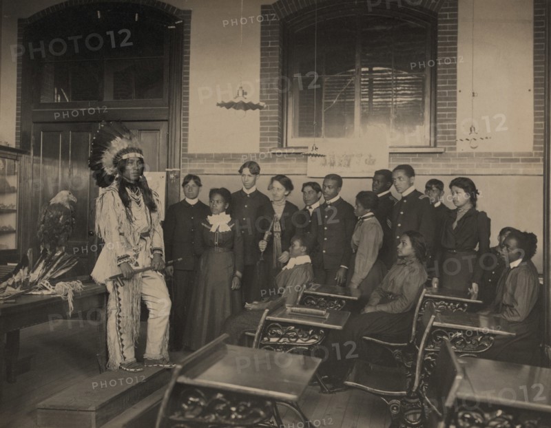Louis Firetail (Sioux, Crow Creek), wearing tribal clothing, in American history..., 1899 or 1900. Creator: Frances Benjamin Johnston.