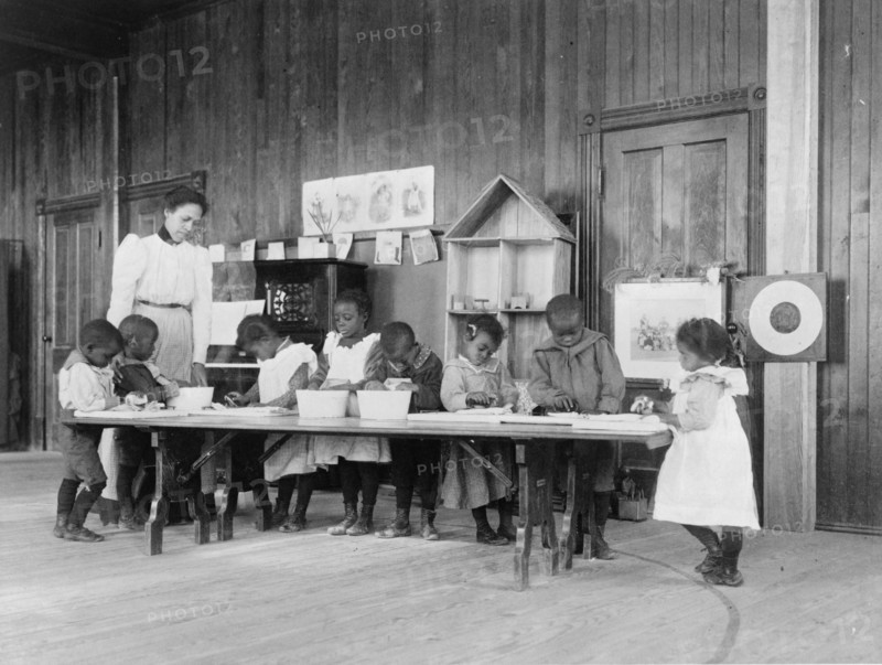 Eight African American children, in kindergarten, learning washing and ironing..., 1899 or 1900. Creator: Frances Benjamin Johnston.