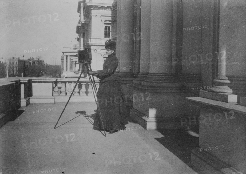 Frances Benjamin Johnston with camera on balcony of State, War and Navy Building..., 1888. Creator: Frances Benjamin Johnston.