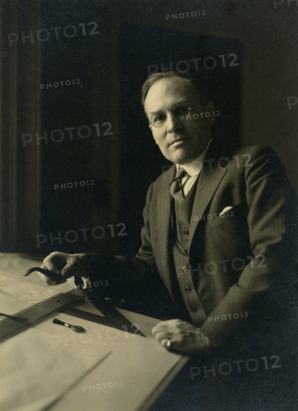 Leicester B. Holland, Chief of Fine Arts Division, Library of Congress posed...table, (1930?). Creator: Frances Benjamin Johnston.