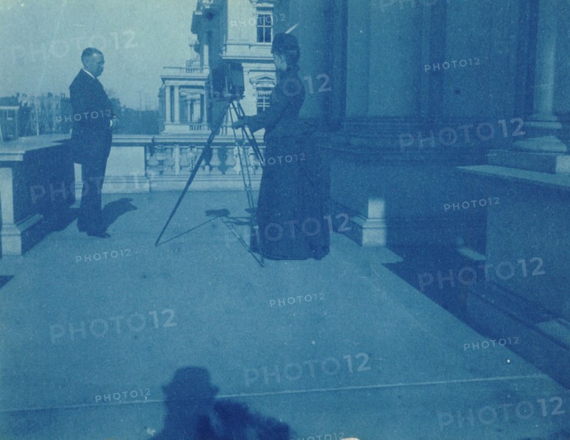 Frances Benjamin Johnston on a balcony of the State, War and Navy Building with a tripod..., 1888. Creator: Frances Benjamin Johnston.