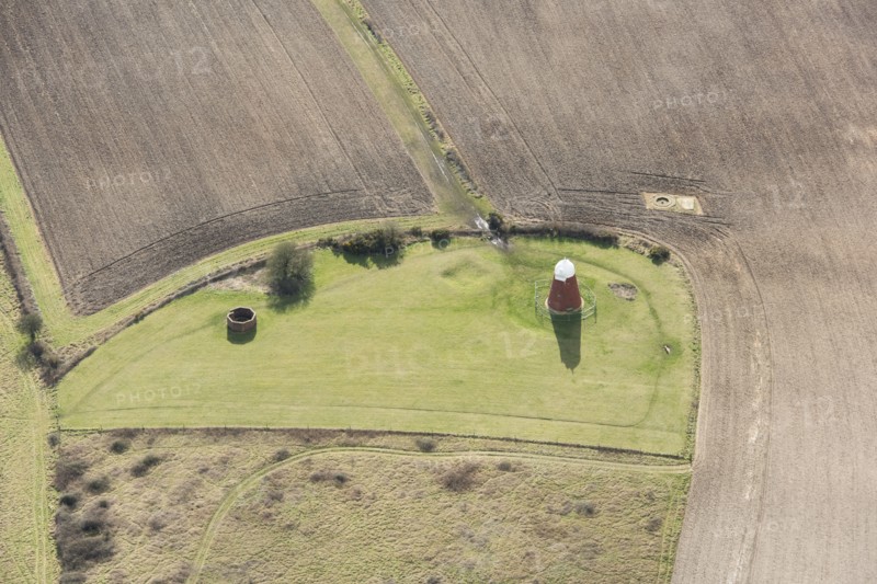 A tower windmill and World War II searchlight emplacements on Halnaker Hill causewayed enclosure, West Sussex, 2018.