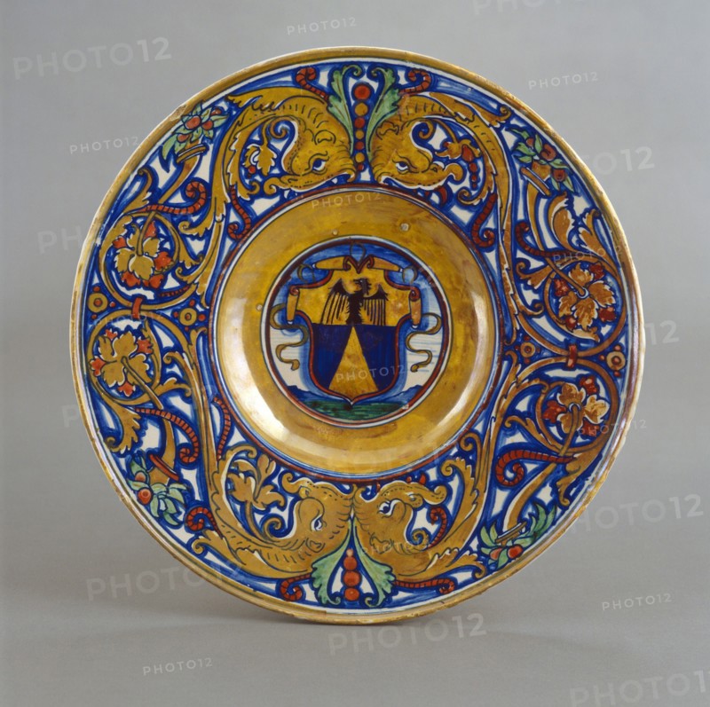 Plate with border of foliate scrollwork with dolphin heads and cornucopias; in the center..., 1524. Creator: Giorgio Andreoli workshop.