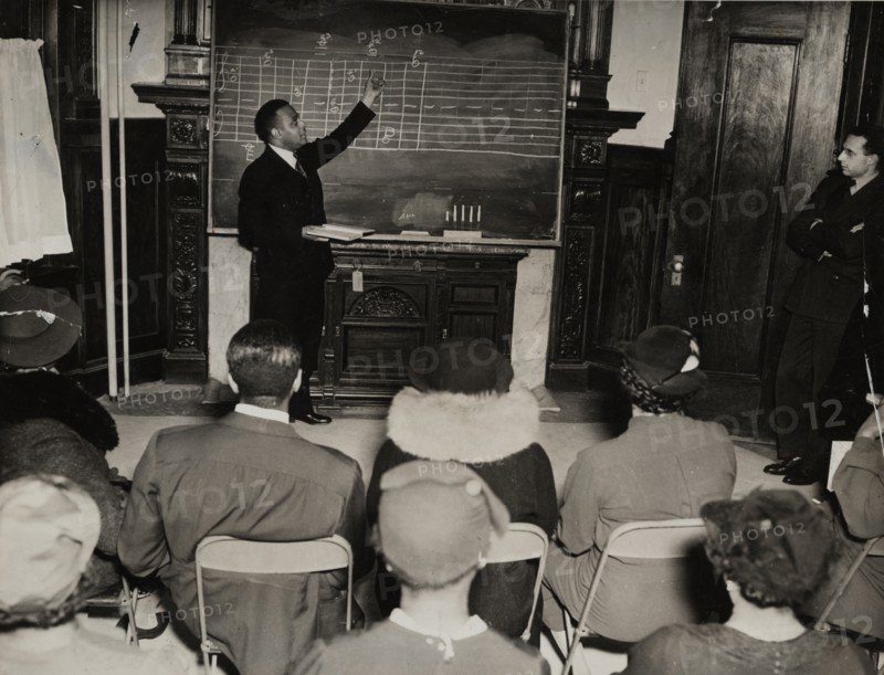 Music class with instructor at the board, 1935 - 1943.
