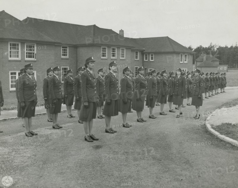 Army nurses standing at attention in front of their barracks and being inspected by..., 1939 - 1945. Creator: Unknown.