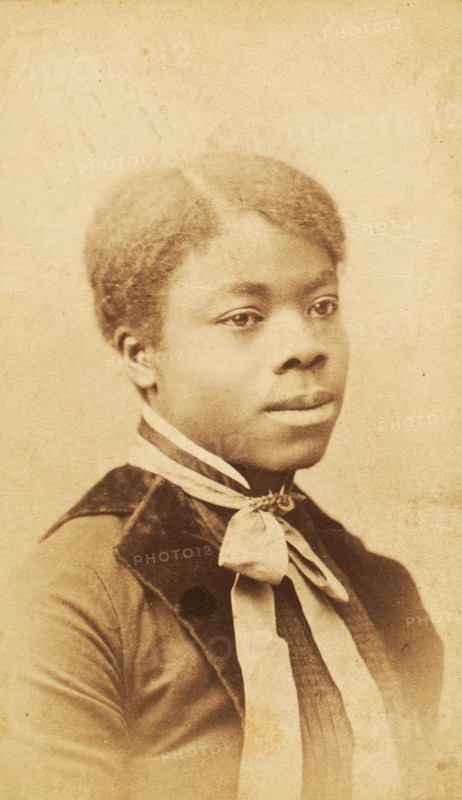 Portrait of young woman with velvet lapels and ribbon bow around neck, (1880-1889?). Creator: LV Bean.