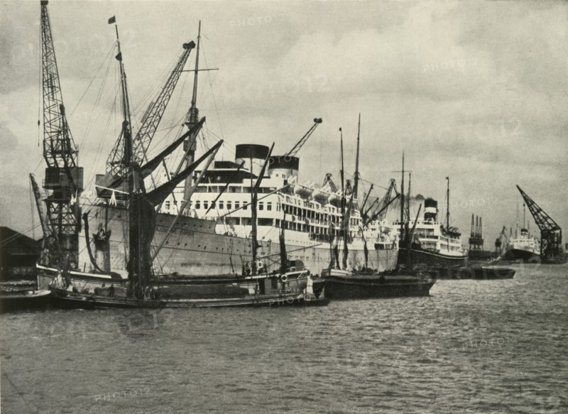 The Forest of Masts Has Given Place to a Cluster of Steamer Funnels Vessels Berthed at...', 1937. Creator: Unknown.