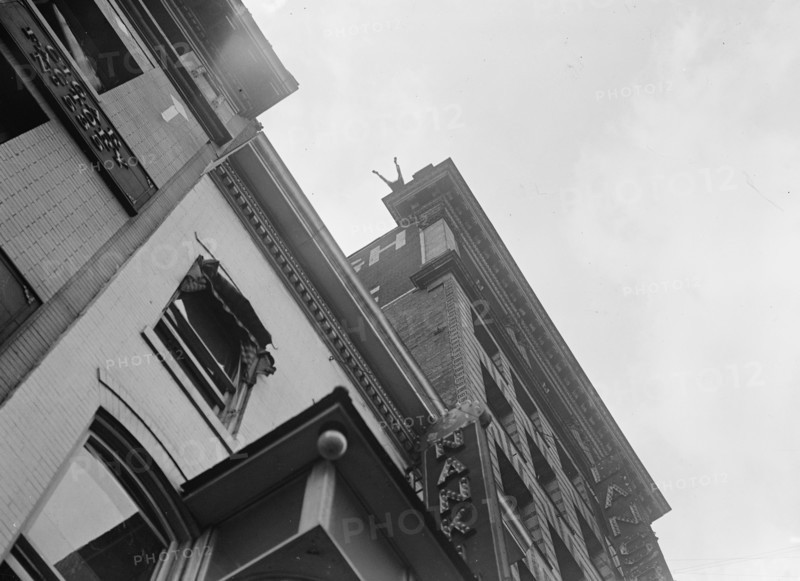 J. Reynolds, Performing Acrobatic And Balancing Acts On High Cornice Above 9th Street, N.W., 1917. Creator: Harris & Ewing.
