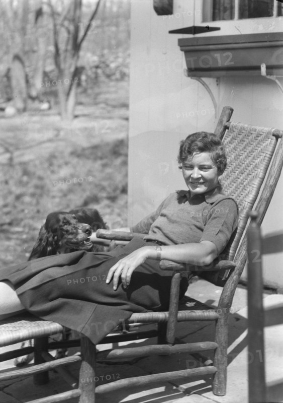 DeLamar, Alice, Miss, with dog, seated outdoors, between 1927 and 1942. Creator: Arnold Genthe.