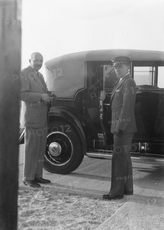 Rothbart, Albert, Mr., standing by his car with his chauffeur, between 1920 and 1935. Creator: Arnold Genthe.