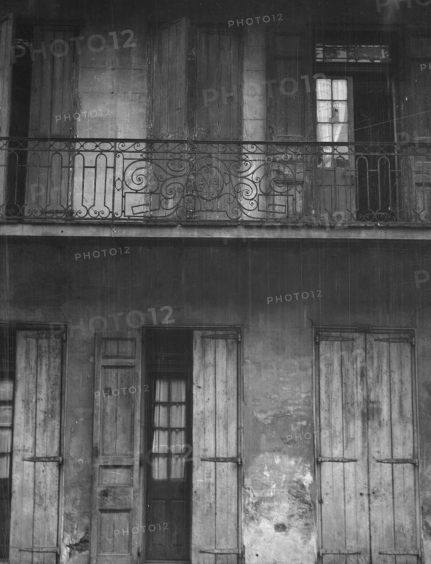 Facade of a building with shuttered doors and balcony, New Orleans or Charleston..., c1920-1926. Creator: Arnold Genthe.