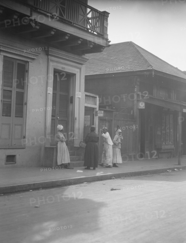View from across street of four women talking, New Orleans, between 1920 and 1926. Creator: Arnold Genthe.