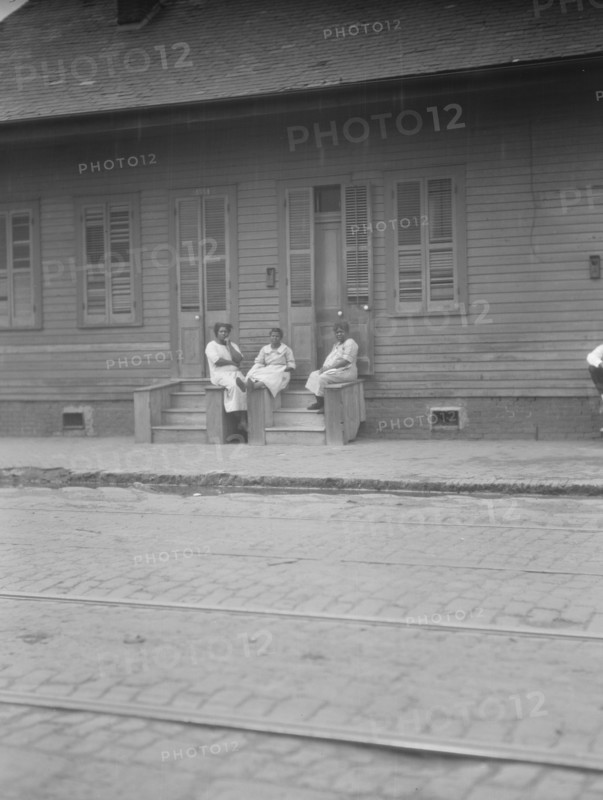 View from across street of three women talking, New Orleans or Charleston, South Ca., c1920-c1926. Creator: Arnold Genthe.
