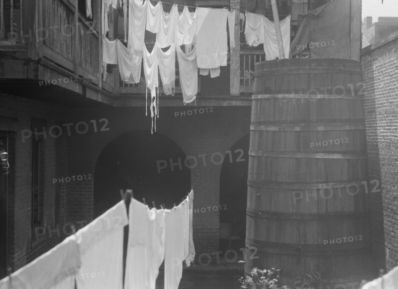 Courtyard with cistern and hanging laundry, New Orleans, between 1920 and 1926. Creator: Arnold Genthe.