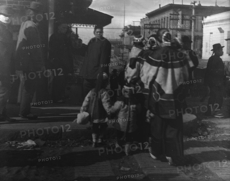 Women and children crossing a street, Chinatown, San Francisco, between 1896 and 1906. Creator: Arnold Genthe.