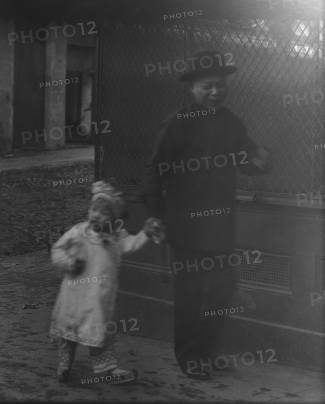 Man and a young child walking down a street, Chinatown, San Francisco, between 1896 and 1906. Creator: Arnold Genthe.