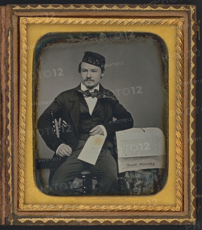 Portrait of seated man holding the Charleston Zeitung, possibly the owner of the newspaper..., 1853. Creator: Unknown.