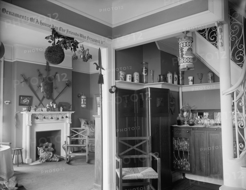Hallway with liquor cabinet and living room decorated with mistletoe ball and Christm..., c1900-1915 Creator: Unknown.