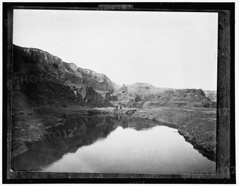 Two women by water, rocky cliffs in background, between 1900 and 1906. Creator: Unknown.
