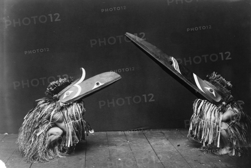 Kotsuis and Hohhug-Nakoaktok, wearing ceremonial dress, with long beaks, on their haunches..., c1914 Creator: Edward Sheriff Curtis.