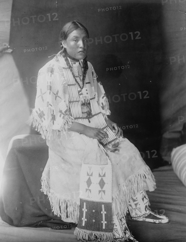 Red Elk Woman, a Sioux girl, full-length portrait, seated, facing right, c1907. Creator: Edward Sheriff Curtis.