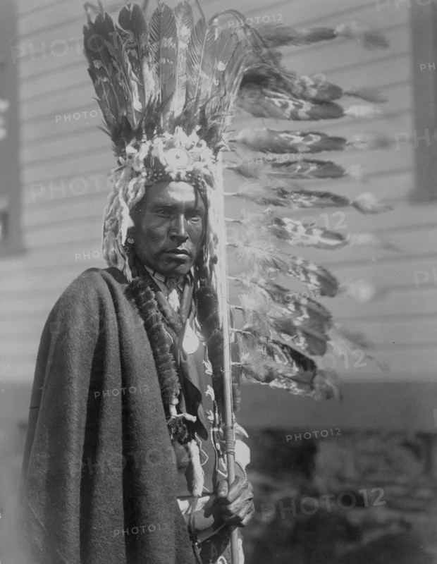 Piegan war-bonnet and coup-stick, c1910. Creator: Edward Sheriff Curtis.