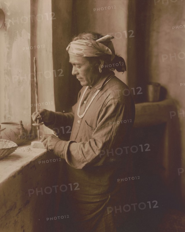Zuni Indian bead worker drilling holes in beads, c1903. Creator: Edward Sheriff Curtis.