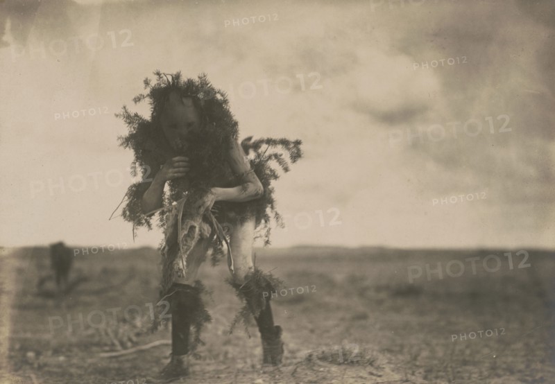 Yeibichai, the beggar, Tonenili-Navajo Indian, dressed in spruce branches, 1904, c1905. Creator: Edward Sheriff Curtis.